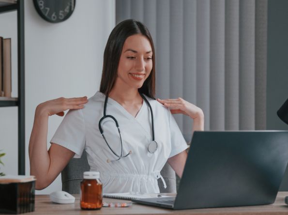 German doctor demonstrating an exercise on a laptop during an online consultation